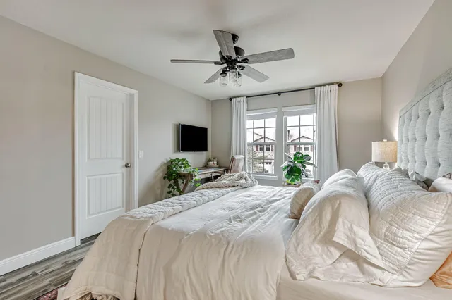 a bedroom with bed and a flat tv screen on dresser