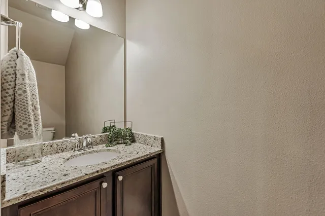 a white toilet sitting next to a white wall