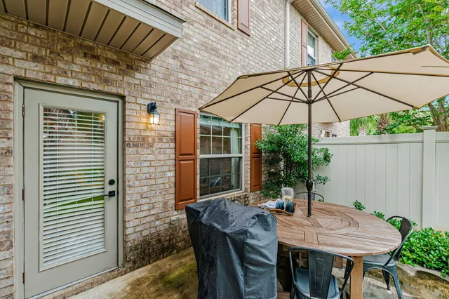 a view of a chair and table in backyard of the house
