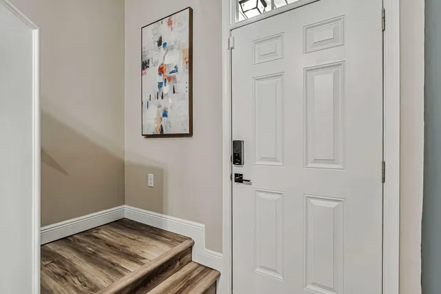 a view of a hallway with wooden floor and closet