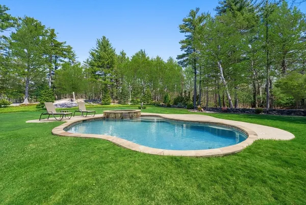 an aerial view of a house with backyard space and swimming pool