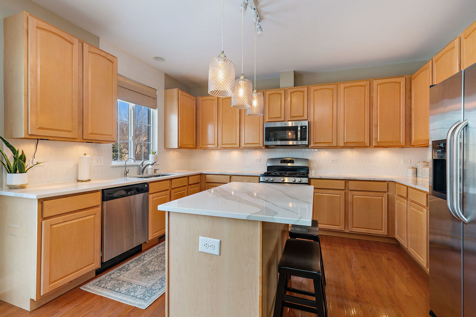1502 Summerhill Lane Cary, IL 60013 - Photo 6 of 17 a kitchen with kitchen island granite countertop a sink appliances cabinets and a counter top space