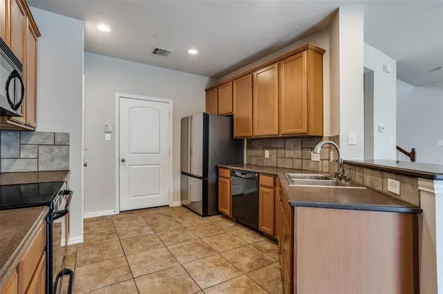 a kitchen with stainless steel appliances granite countertop a refrigerator sink and stove