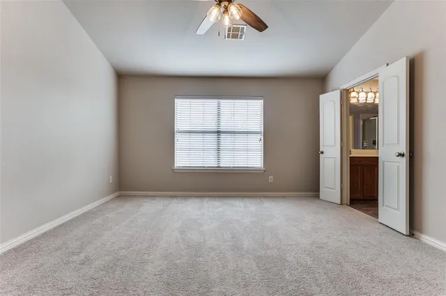 an empty room with a window and a kitchen
