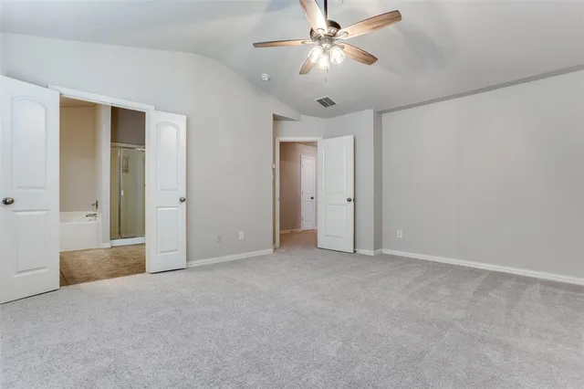 a view of an empty room with a ceiling fan