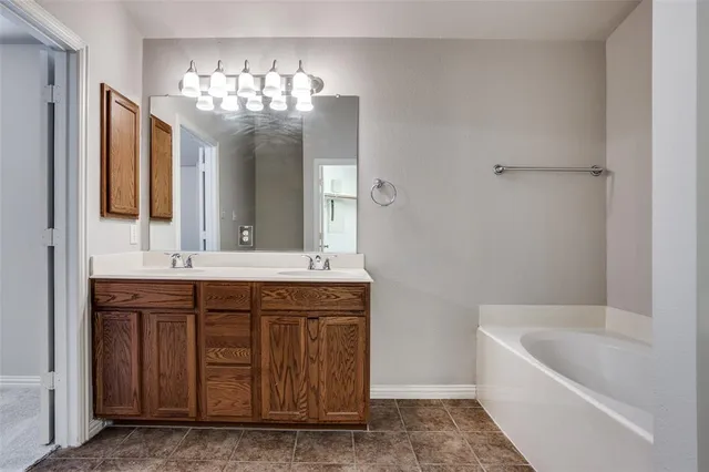 a bathroom with a tub a sink and mirror