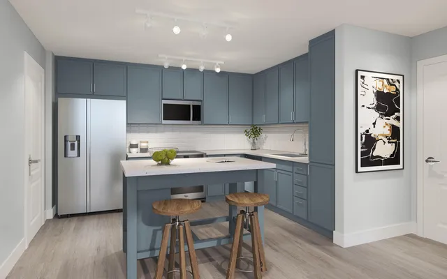 a kitchen with a refrigerator a sink and chairs