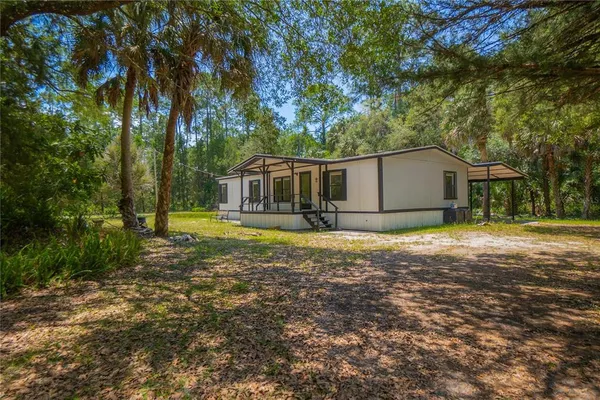 a view of a house with backyard and tree