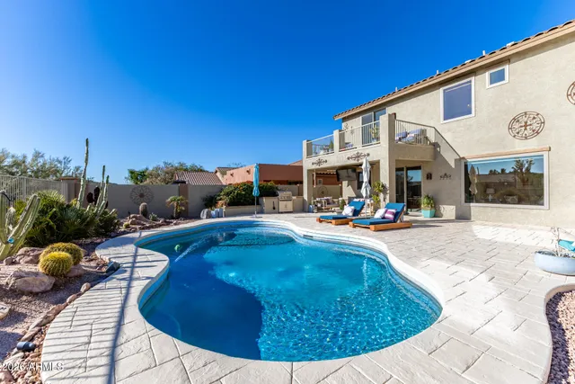 an aerial view of a balcony with table and chairs