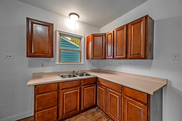 a kitchen with stainless steel appliances granite countertop cabinets sink and wooden floor