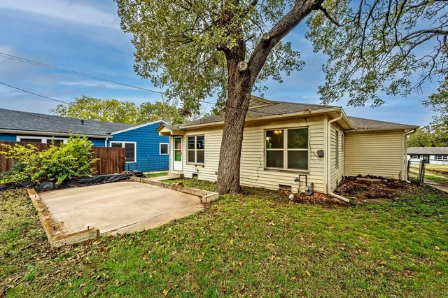 a backyard of a house with yard table and chairs