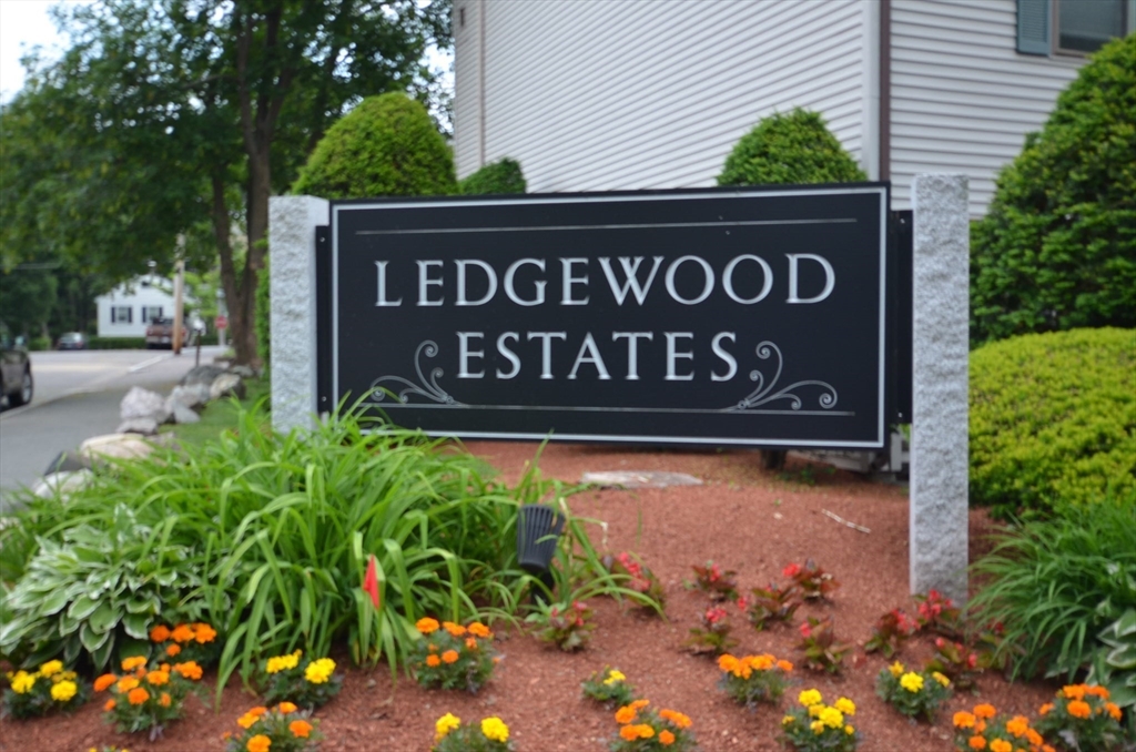 a sign that is sitting in front of flowers