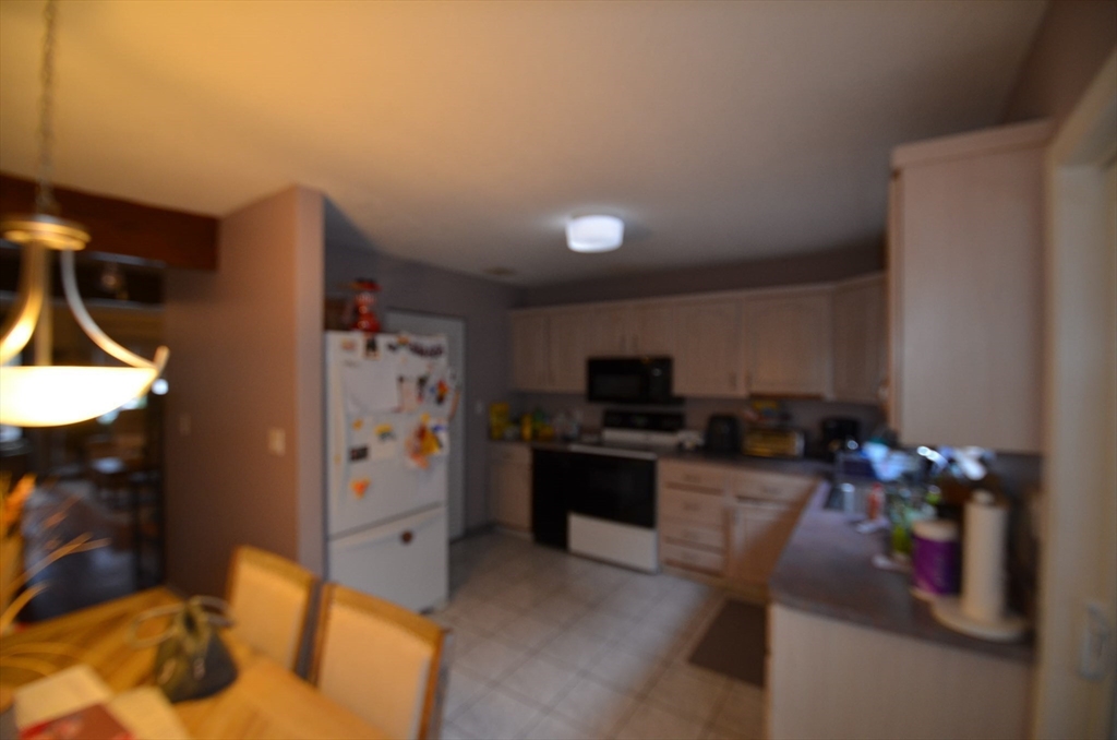 2 Rocky Nook, Unit 2 Malden, MA 02148 - Photo 9 of 27 a kitchen with stainless steel appliances kitchen island granite countertop a sink dishwasher stove and refrigerator with wooden floor