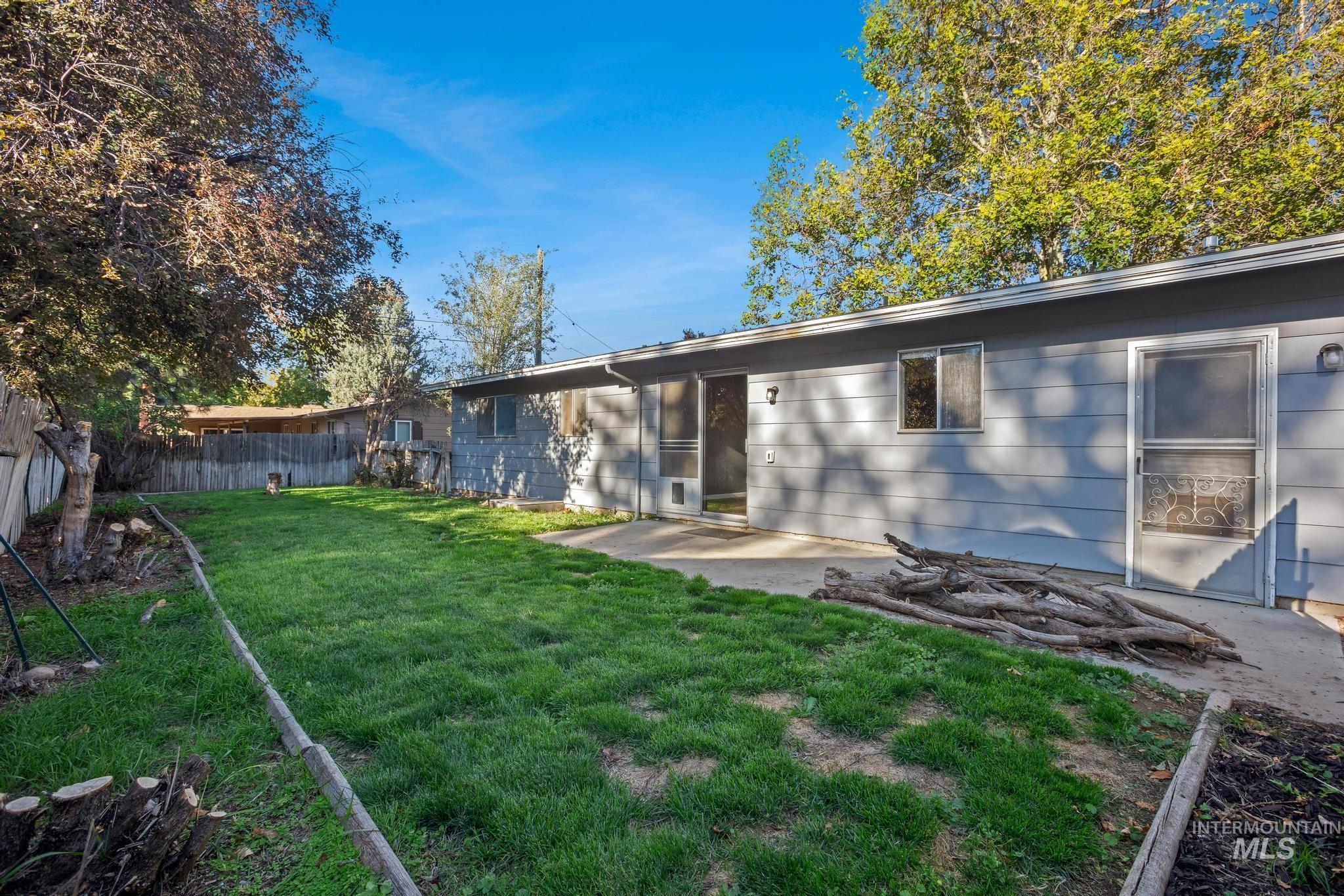 2037 South Curtis Road Boise, ID 83705 - Photo 29 of 32 Rear exterior featuring light grey siding, two screen doors, and a concrete patio