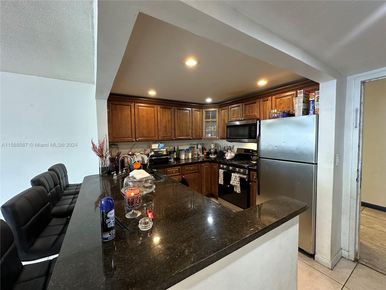 a kitchen with stainless steel appliances granite countertop a sink a stove and a refrigerator