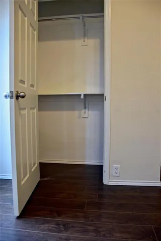 an empty room with wooden floor chandelier fan and windows