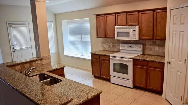 a kitchen with stainless steel appliances granite countertop a sink and a stove