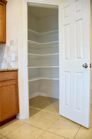 a stove top oven sitting inside of a kitchen with granite countertop wooden cabinets