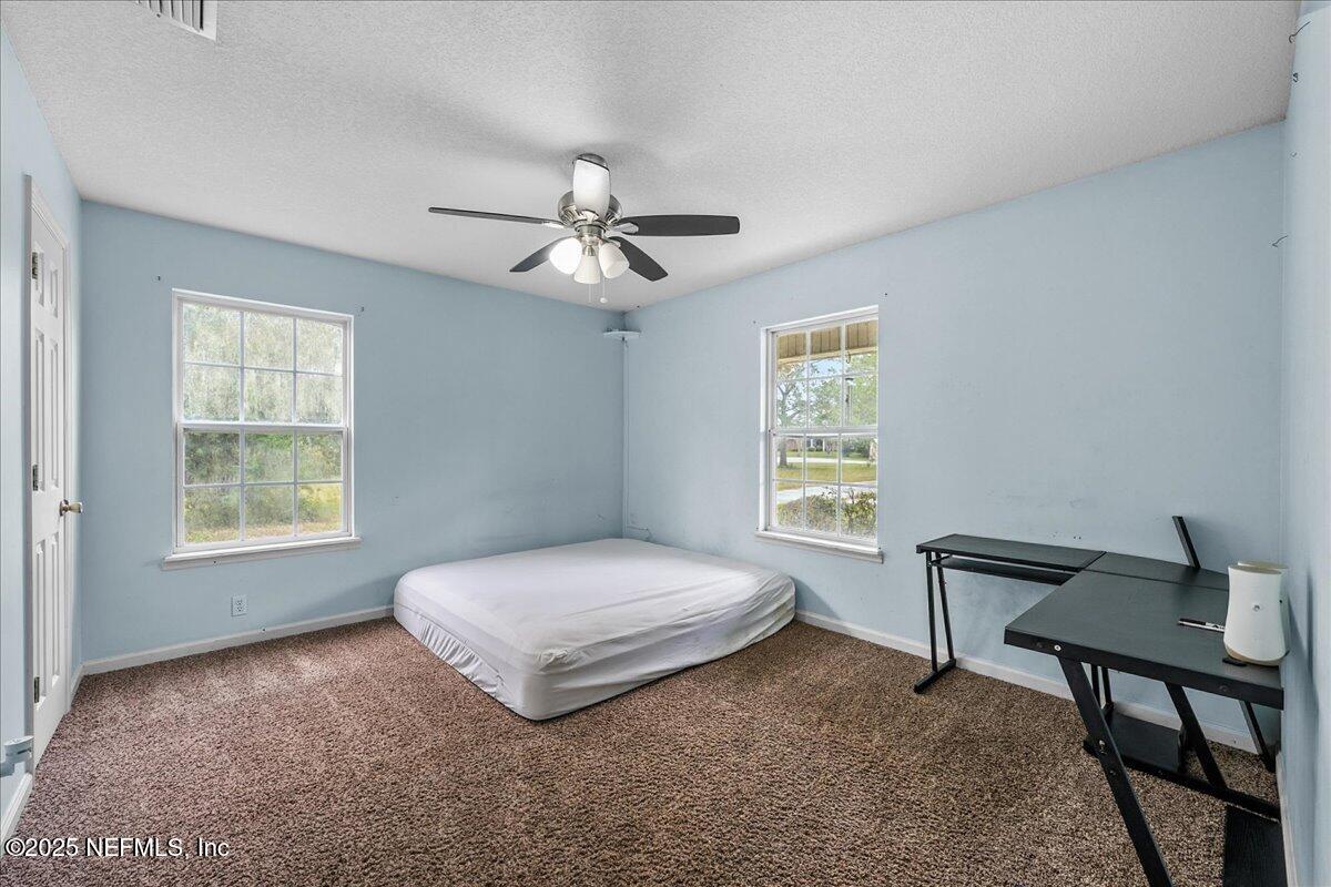 55056 Yellow Jacket Drive Callahan, FL 32011 - Photo 14 of 31 a spacious bedroom with a bed and a window