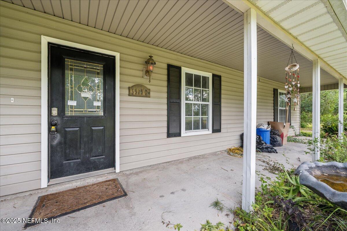 55056 Yellow Jacket Drive Callahan, FL 32011 - Photo 3 of 31 a front view of a house with a porch
