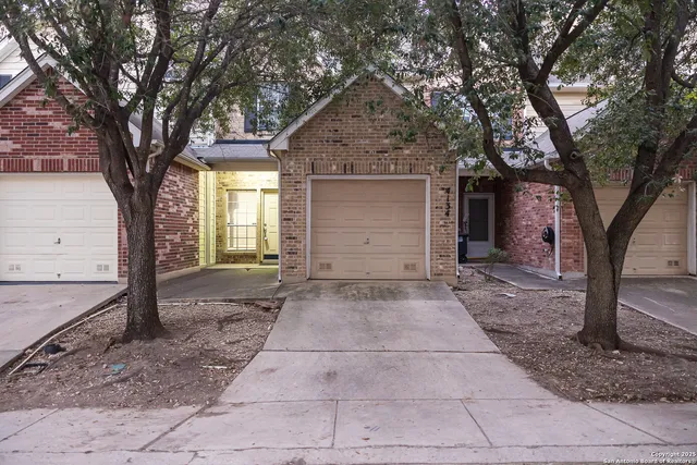 a view of a house with a yard and large tree