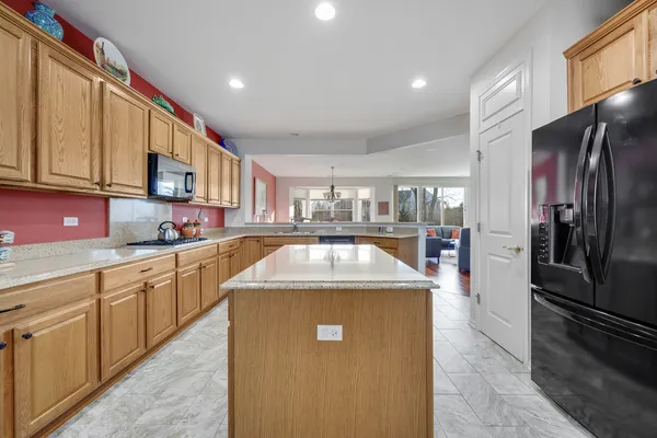 a kitchen with stainless steel appliances granite countertop a sink a stove and a refrigerator