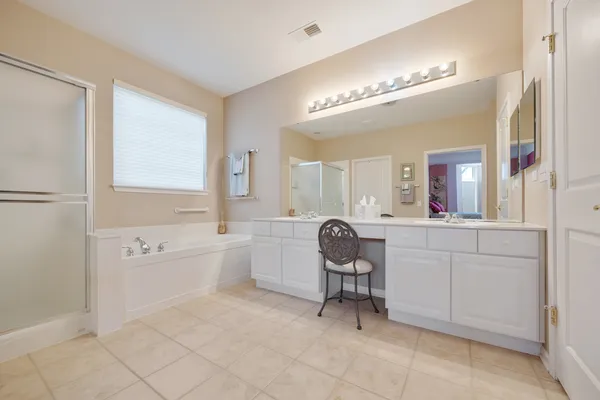 a spacious bathroom with a mirror a bathtub and a sink