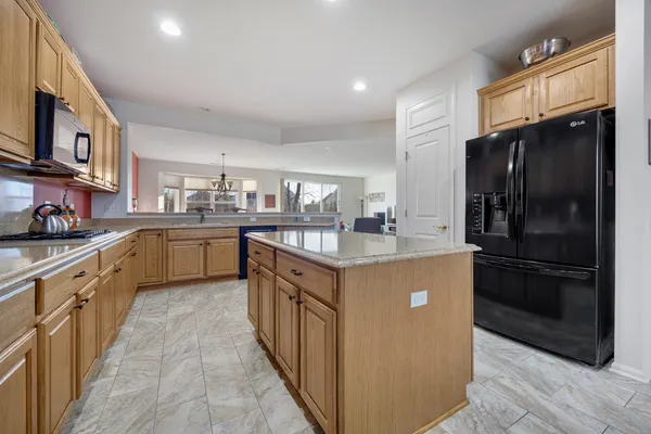a kitchen with stainless steel appliances granite countertop a refrigerator a sink dishwasher stove and oven