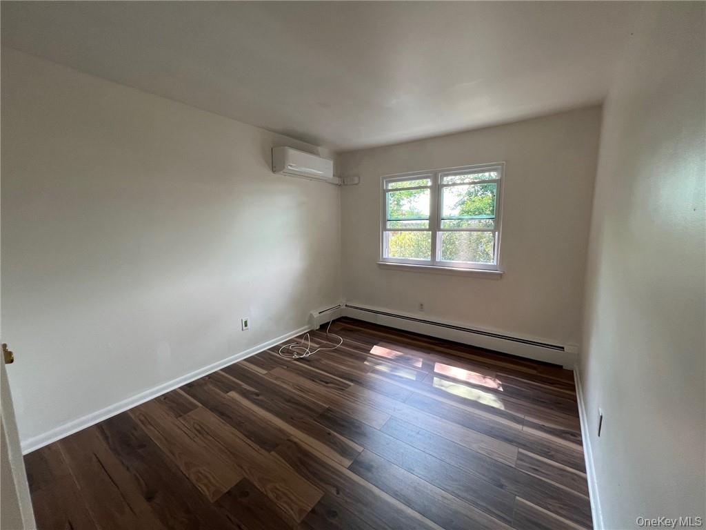 38 Hampton Court Middletown, NY 10941 - Photo 11 of 17 Bedroom #2 room featuring a baseboard heating unit, dark hardwood / wood-style flooring, and an AC wall unit