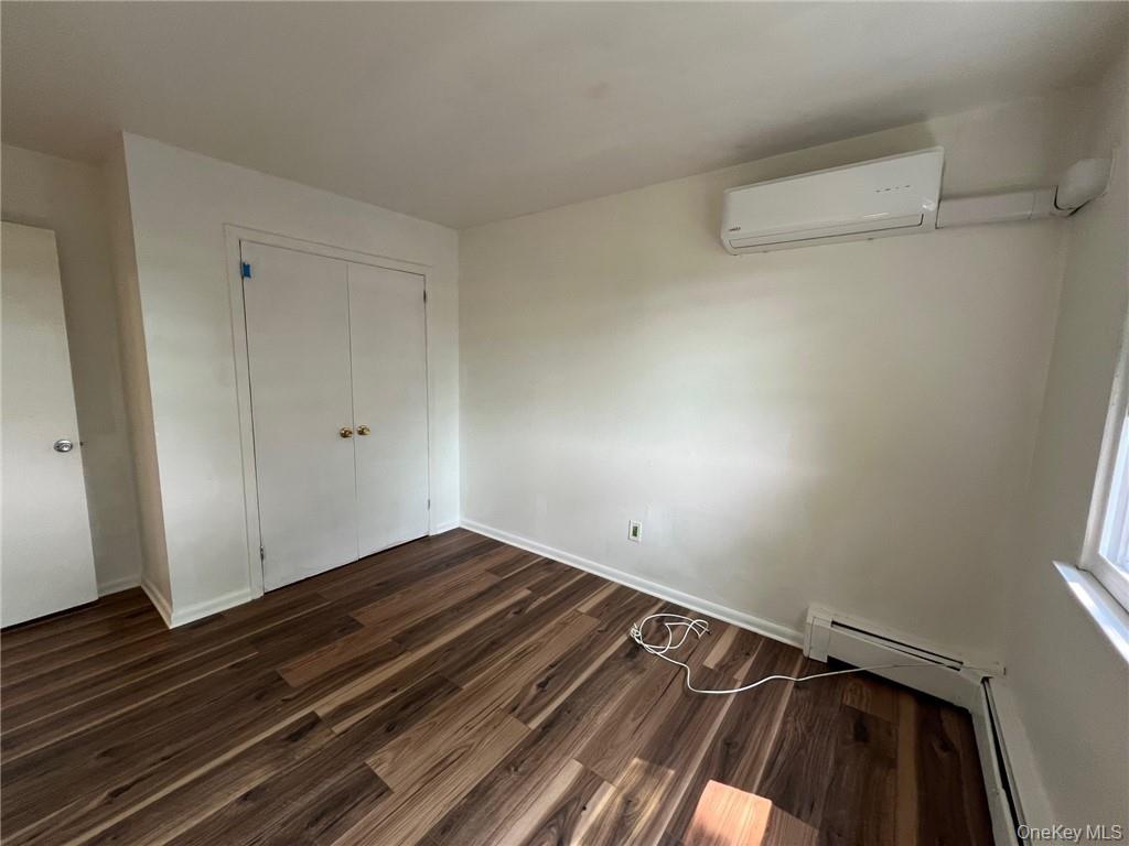 38 Hampton Court Middletown, NY 10941 - Photo 12 of 17 Bedroom #2 featuring dark wood-type flooring, a closet, and a wall mounted air conditioner