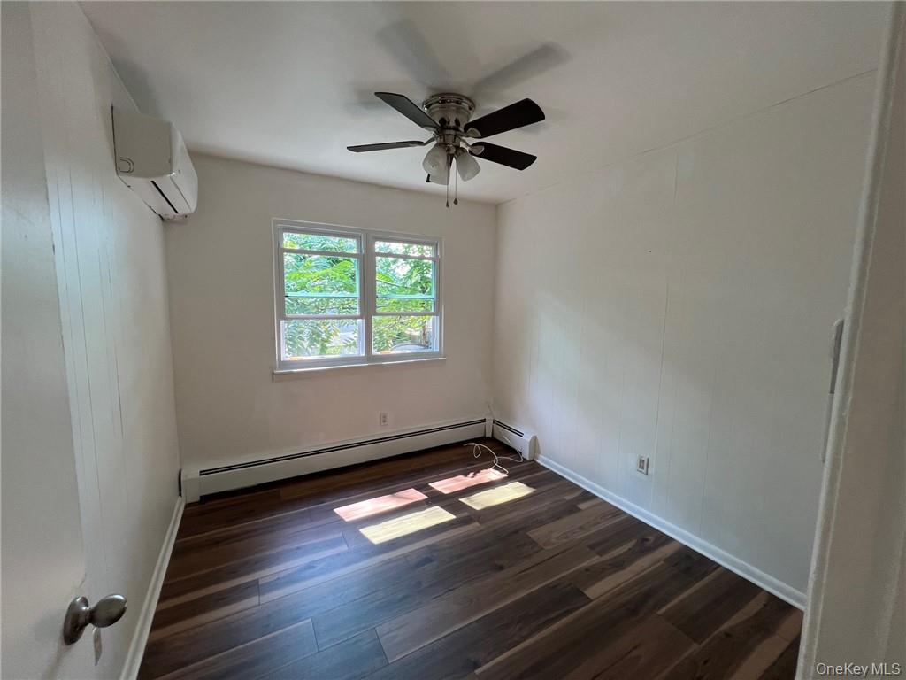 38 Hampton Court Middletown, NY 10941 - Photo 13 of 17 Bedroom #3 with dark wood-type flooring, a baseboard radiator, a wall mounted air conditioner, and ceiling fan