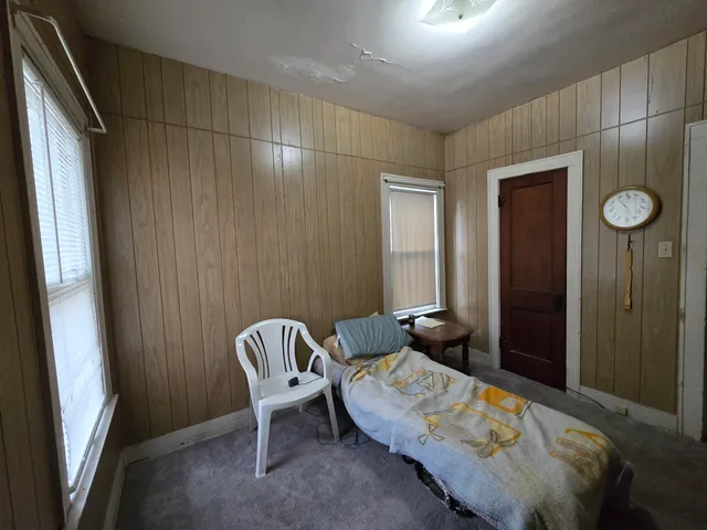 a bedroom with a bed and a chair
