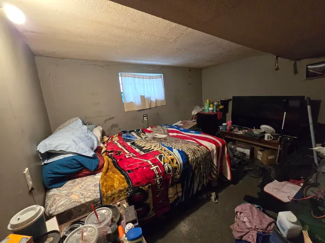 a bedroom with a bed and a lamp on the dresser