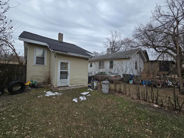 a view of house with backyard and outdoor seating
