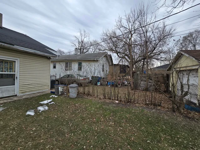 a view of a house with a yard and a large tree