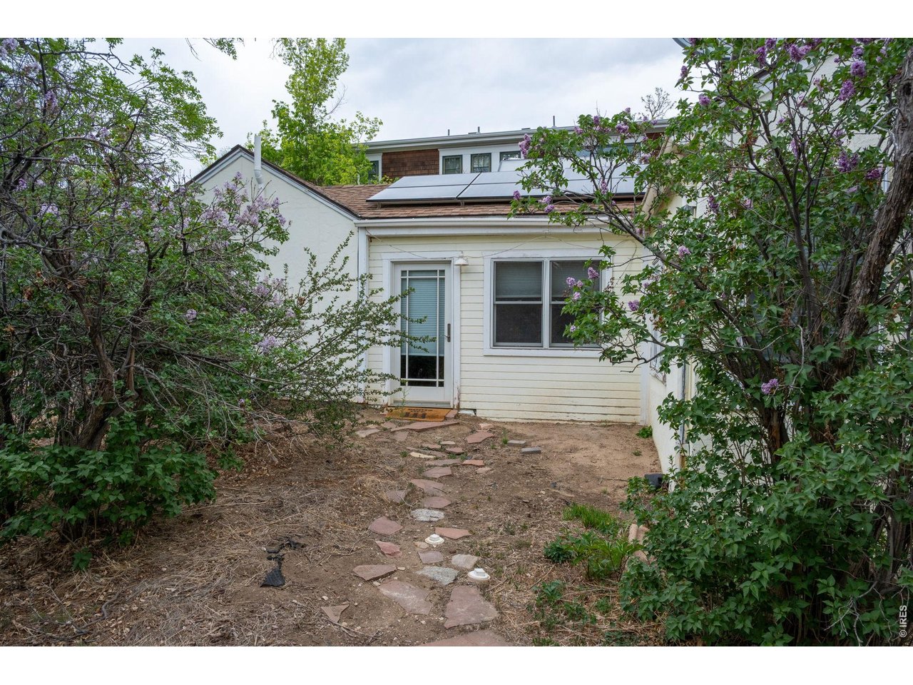 3005 6th Street Boulder, CO 80304 - Photo 30 of 41 a view of a white house with large windows and a tree