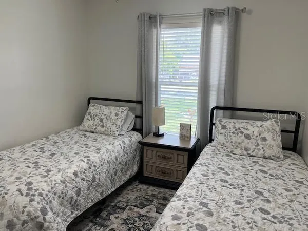 a large bed sitting in a bedroom next to a window