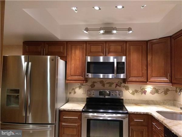 1101 South Arlington Ridge Road, Unit 213 Arlington, VA 22202 - Photo 4 of 6 a kitchen with a refrigerator stove and microwave