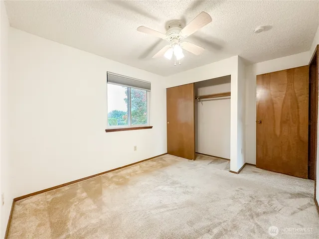 an empty room with a ceiling fan and a window