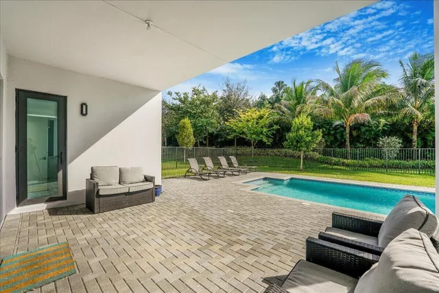 a view of swimming pool with lounge chair in front of house
