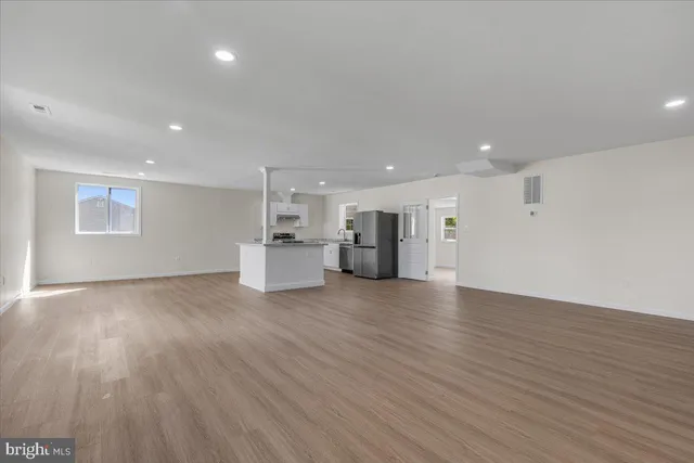 a view of empty room with wooden floor