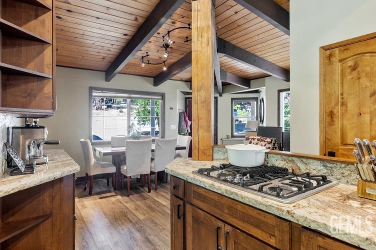 Undisclosed Address Wofford Heights, CA 93285 - Photo 22 of 35 a kitchen with a stove a sink dishwasher and a dining table with garden view