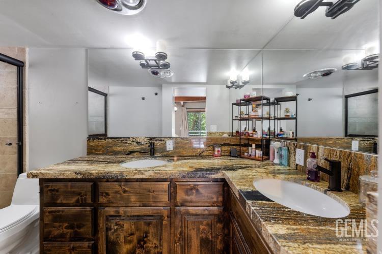 Undisclosed Address Wofford Heights, CA 93285 - Photo 26 of 35 a bathroom with a granite countertop sink a mirror and vanity