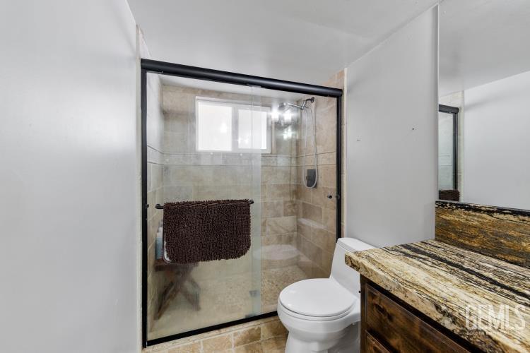 Undisclosed Address Wofford Heights, CA 93285 - Photo 27 of 35 a bathroom with a granite countertop toilet a sink and a shower