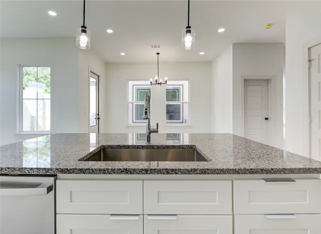 a kitchen with granite countertop kitchen island white cabinets and a granite counter tops