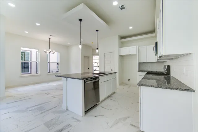 a large kitchen with granite countertop a stove a sink a refrigerator and a granite counter tops