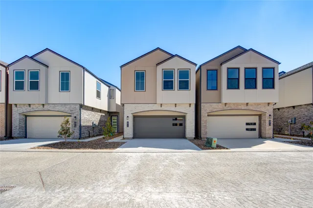a view of a white house with a yard and parking space