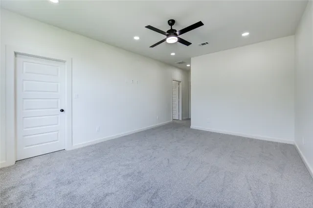 an empty room with closet and fan