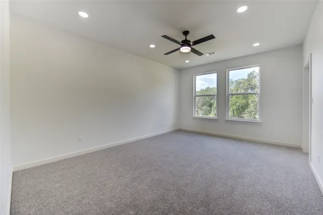 an empty room with a window and a fan