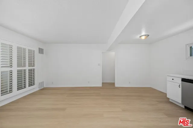 a view of a big room with wooden cabinet and windows